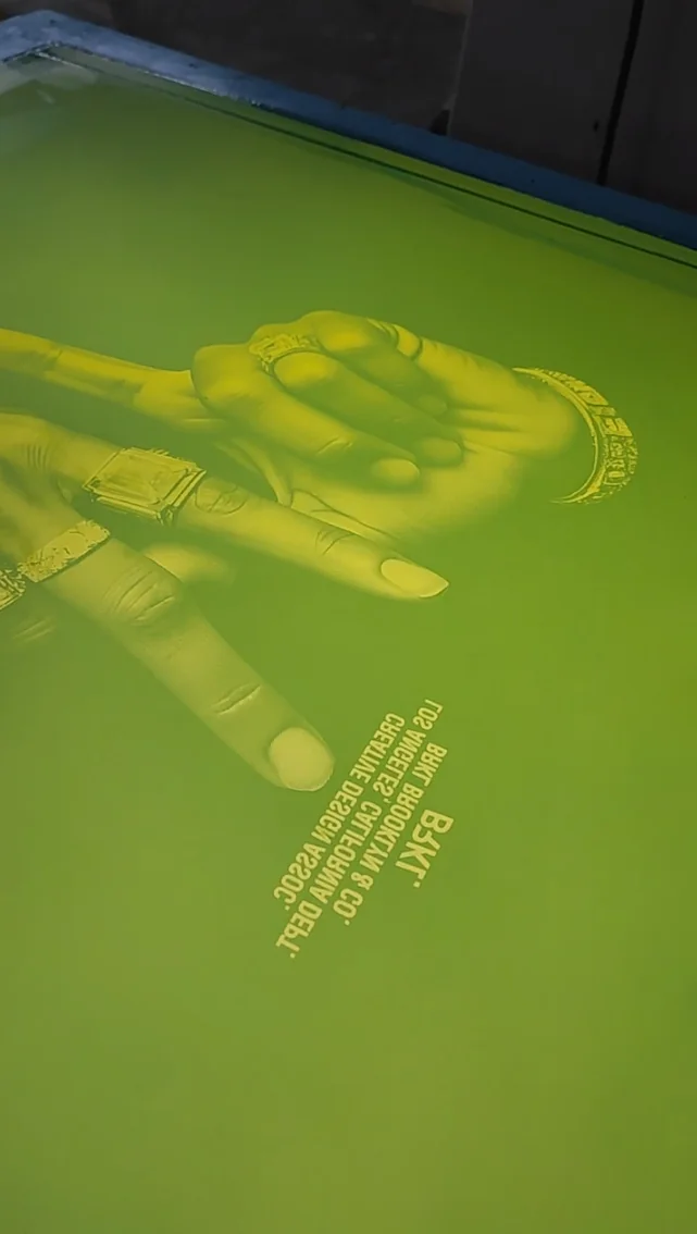 Pantalla de serigrafía revelada con una imagen de manos y texto fino
